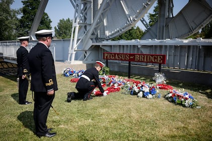 Military officials lay a wreath of flowers at the Pegasus Bridge, one of the first sites liberated by Allied forces from Nazi Germany, in Benouville, Normandy, Monday, June 5, 2023.