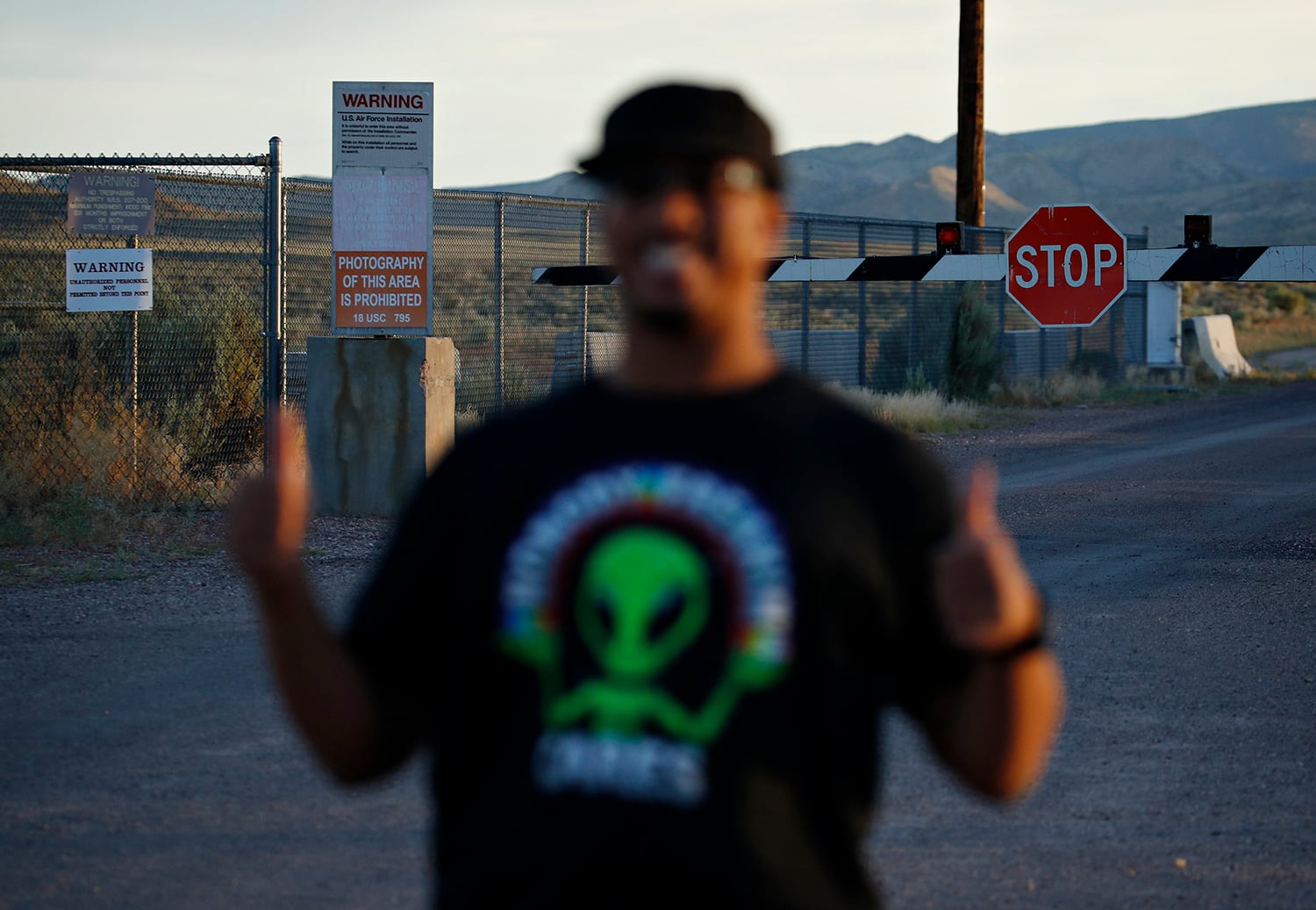 In this July 22, 2019, photo, Stan Evans poses as he has his picture taken while visiting an entrance to the Nevada Test and Training Range near Area 51 outside of Rachel, Nev.