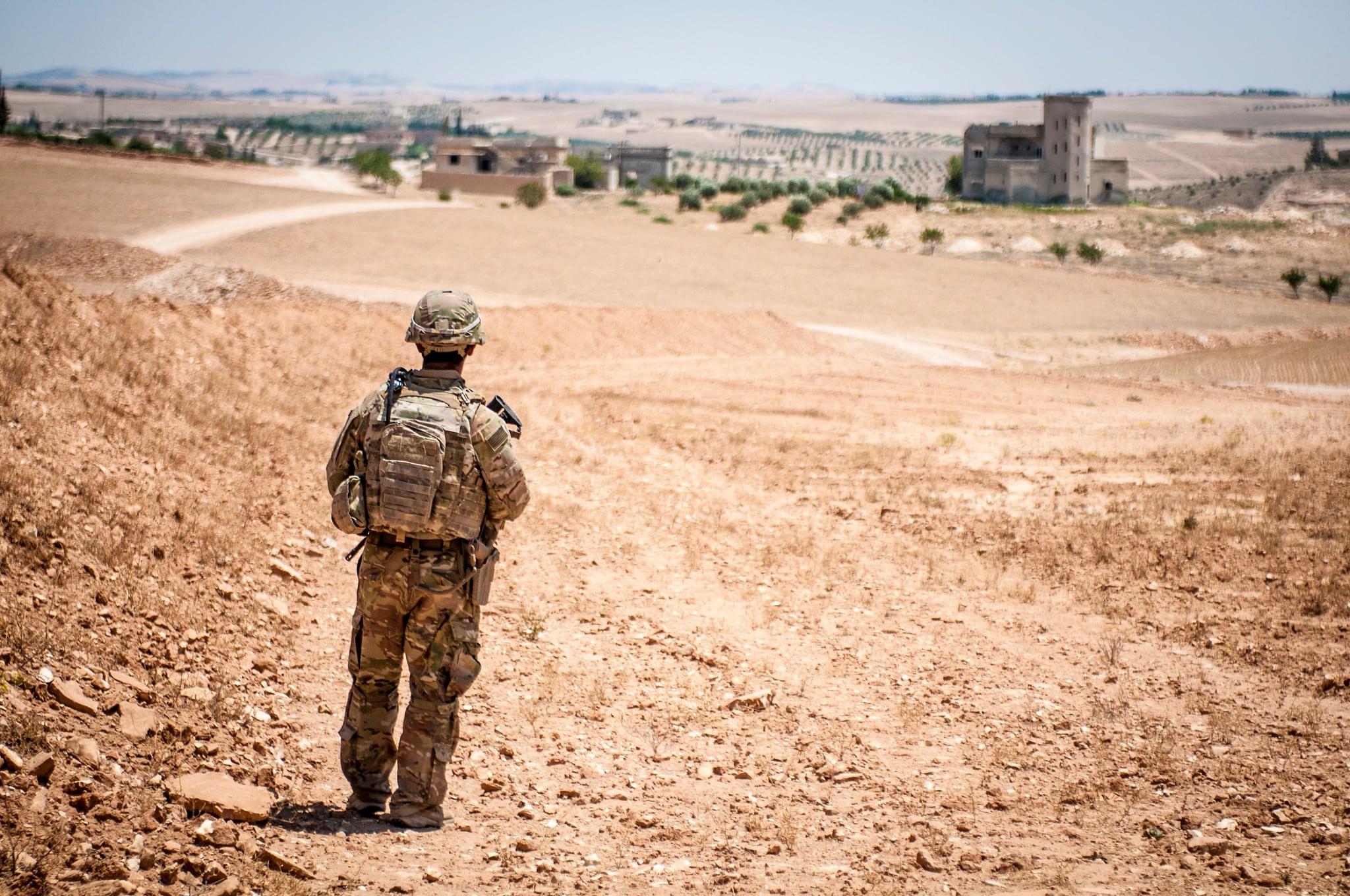 A U.S. soldier provides security during a coordinated, independent patrol along the demarcation line near a village outside Manbij, Syria, June 26, 2018.