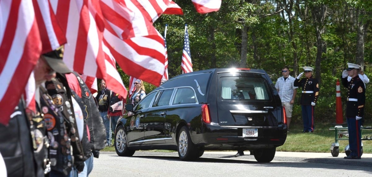 Members of the Patriot Guard Riders line the roadway as the hearse arrives at the National Cemetery in Bourne, where Marine Corps veteran Michael Ferazzi was buried on Friday afternoon.