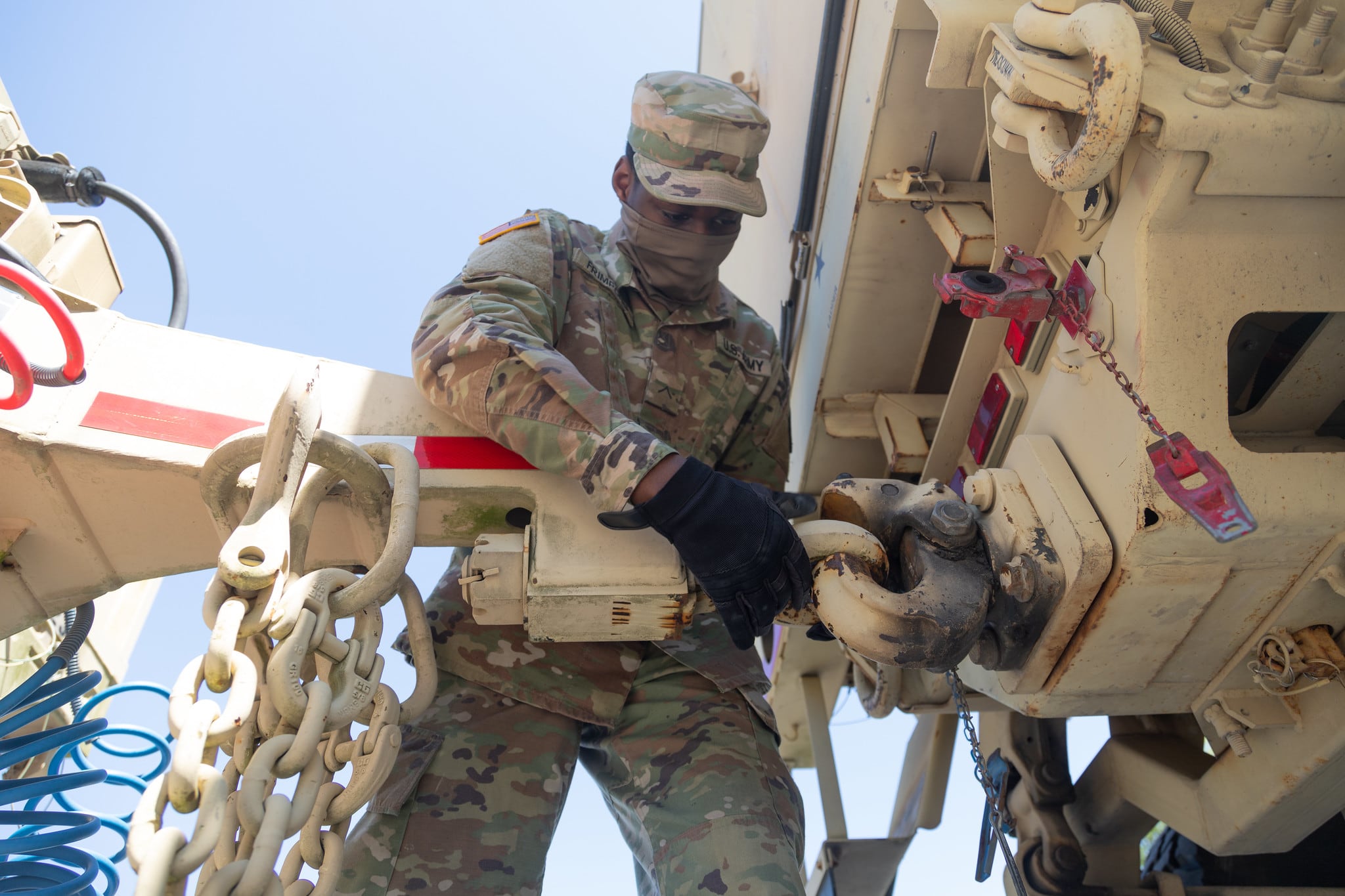 Army Pvt. Rexford Frimpong attaches the trailer to the Light Medium Tactical Vehicle at the production center in Baltimore on May 7, 2020.