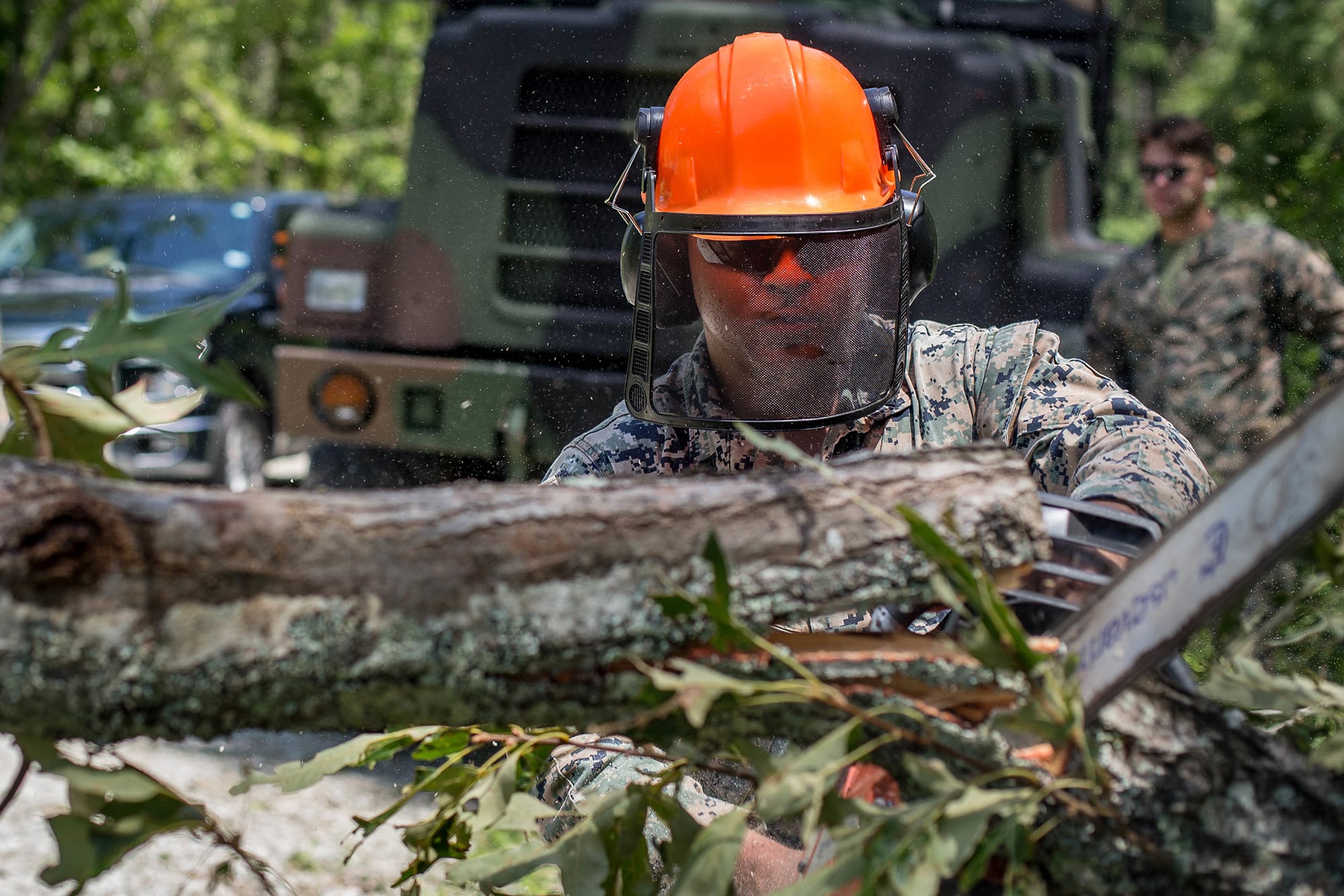 Cpl. William Butler uses a chainsaw to clear debris on a training area road at Marine Corps Air Station New River, N.C., Aug. 4, 2020, after Hurricane Isaias in order to resume normal operations.