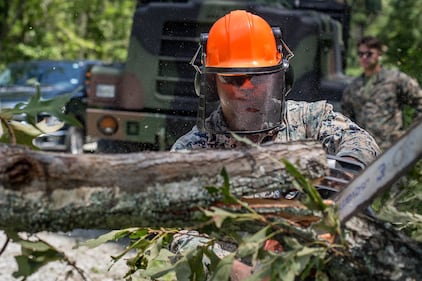 Cpl. William Butler uses a chainsaw to clear debris on a training area road at Marine Corps Air Station New River, N.C., Aug. 4, 2020, after Hurricane Isaias in order to resume normal operations.