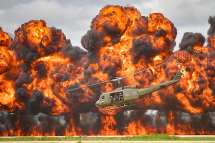 A Bell UH-1 Iroquois Helicopter, nicknamed the "Huey," takes off amidst an explosion Aug. 18, 2019, during a reenactment of a Vietnam-era combat search and rescue mission performed by Cavanaugh Flight Museum at Joe Foss Field, S.D.