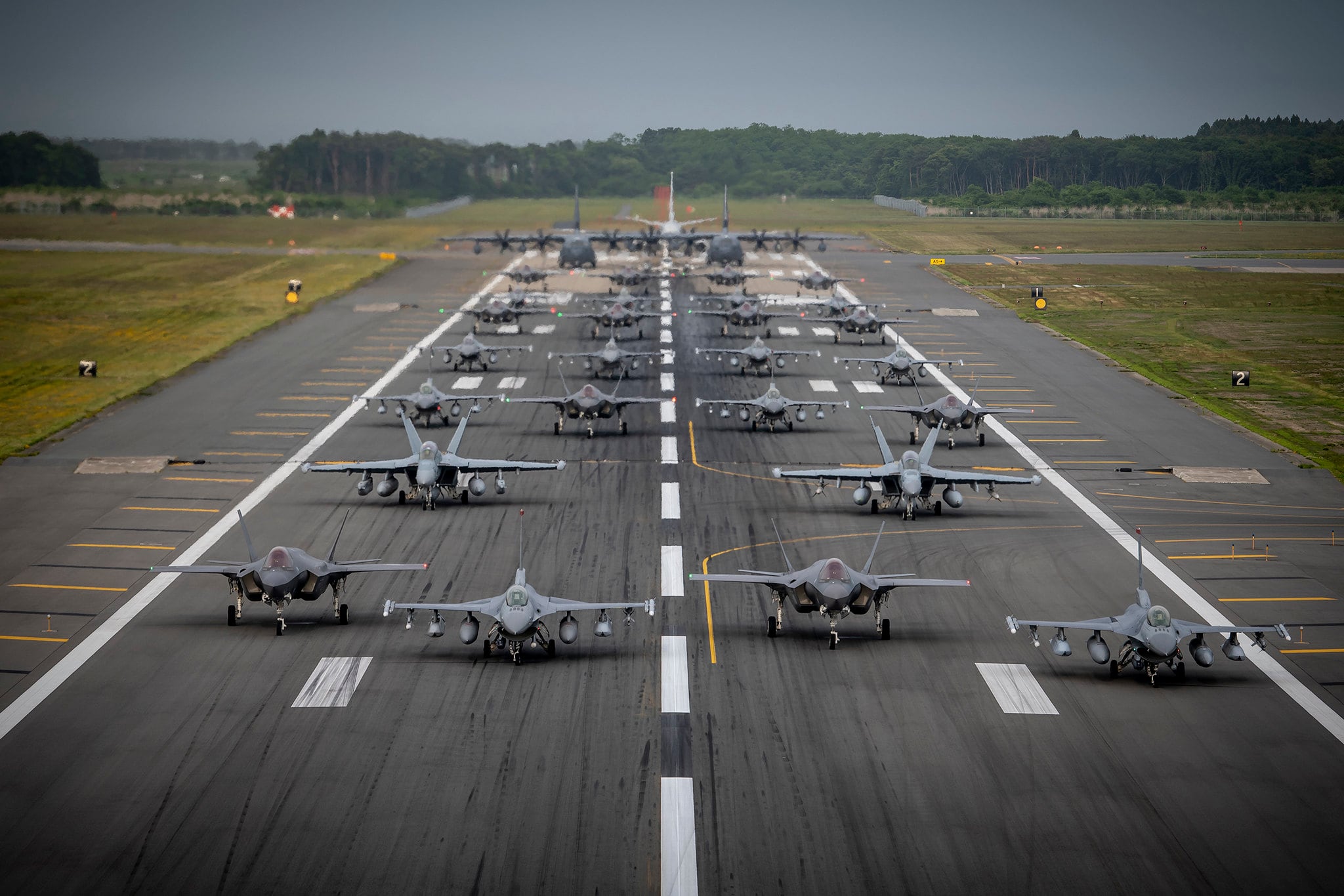 Twelve U.S. Air Force F-16CM Fighting Falcons, 12 Koku-Jieitai F-35A Lightning II Joint Strike Fighters, two U.S. Navy EA-18G Growlers, a USN C-12 Huron, two USAF MC-130J Commando II aircraft, and a USN P-8 Poseidon participate in an “Elephant Walk” at Misawa Air Base, Japan, June 22, 2020.