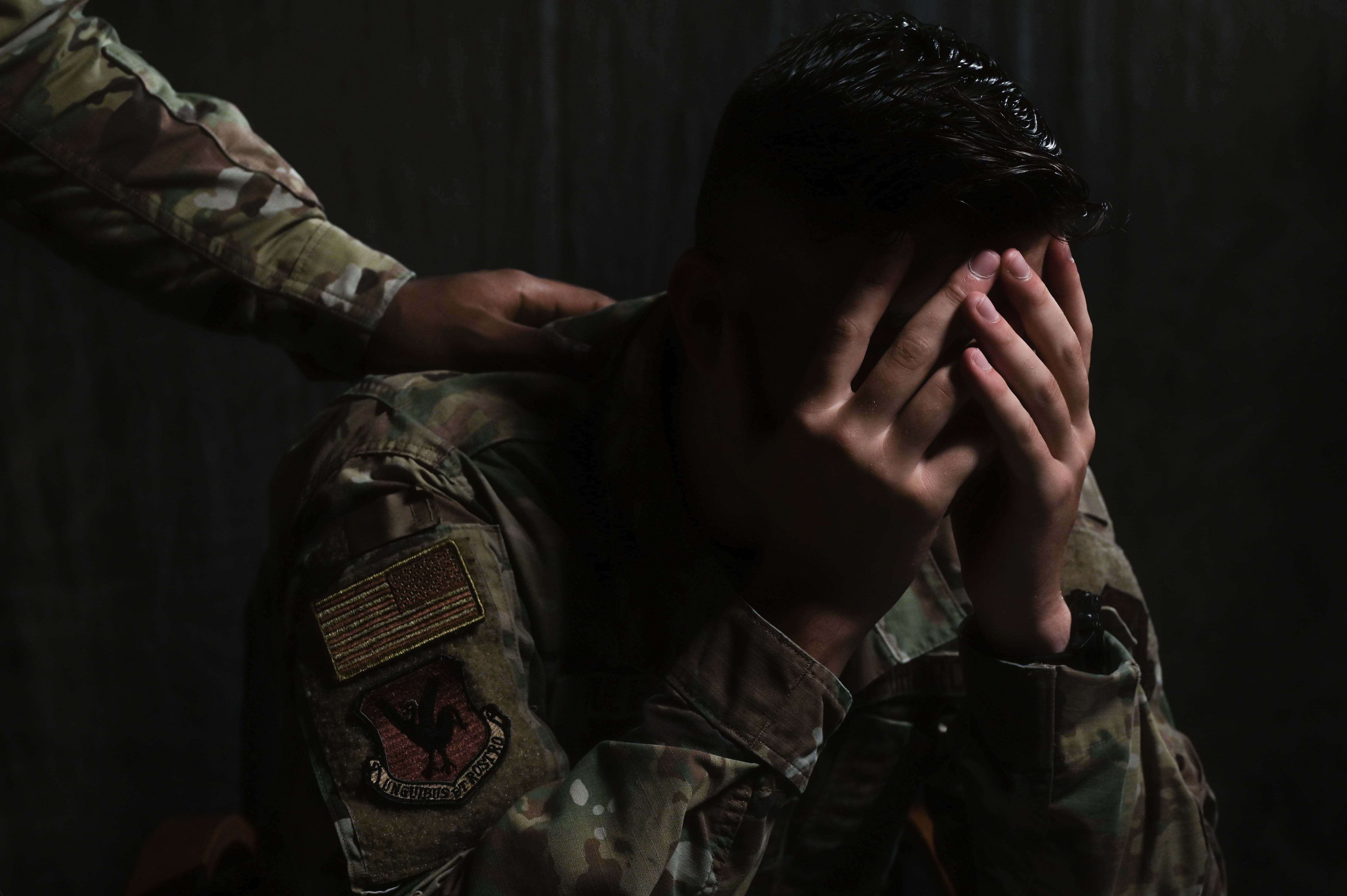 An airman places a hand on the shoulder of another airman at Kadena Air Base, Japan, Aug. 19, 2021.