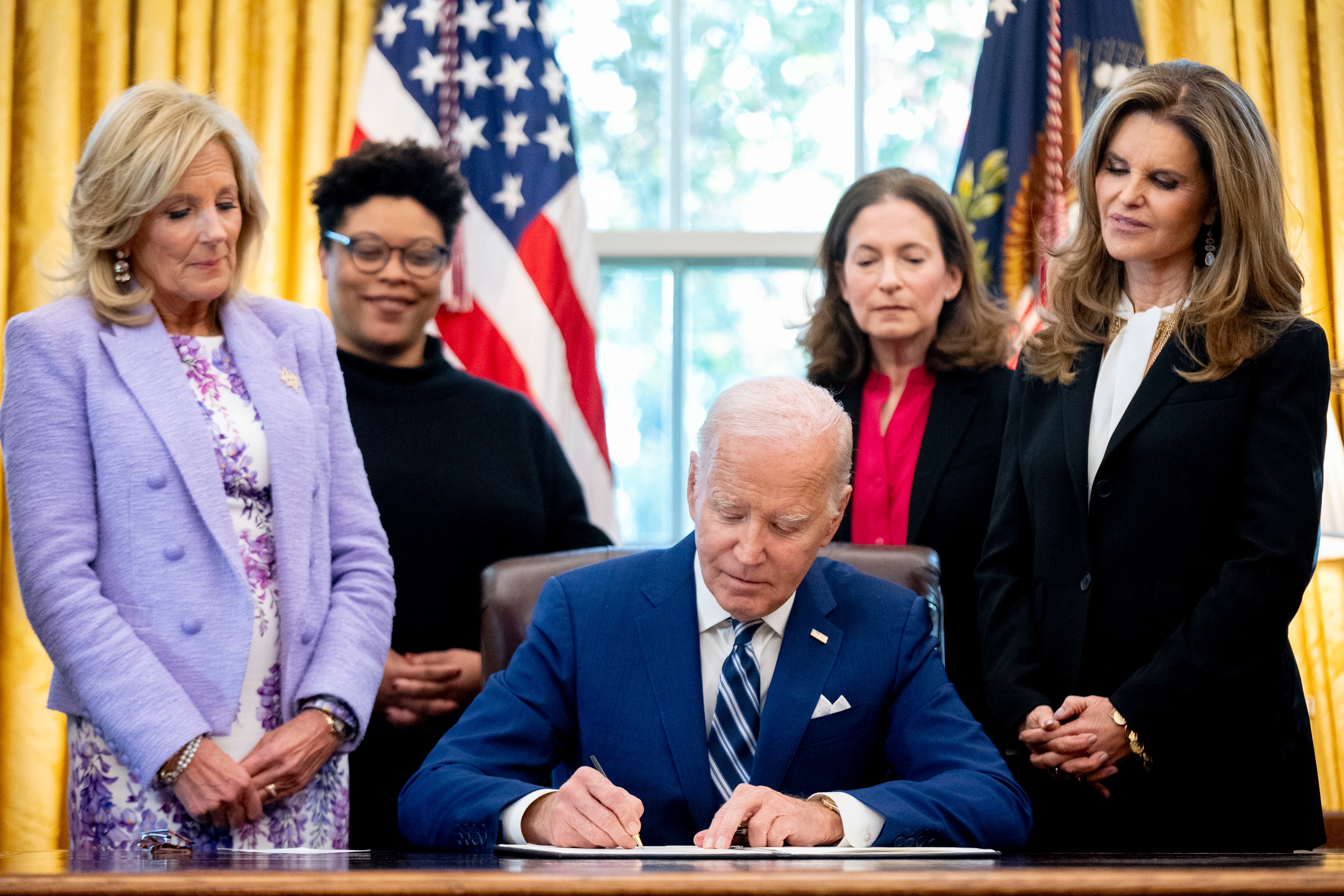 President Joe Biden, accompanied by from left, first lady Jill Biden, Office of Management and Budget director Shalanda Young, White House Gender Policy Council director Jen Klein, and Women's Alzheimer's Movement founder Maria Shriver, signs a presidential memorandum that will establish the first-ever White House Initiative on Women's Health Research in the Oval Office of the White House, Monday, Nov. 13, 2023, in Washington.