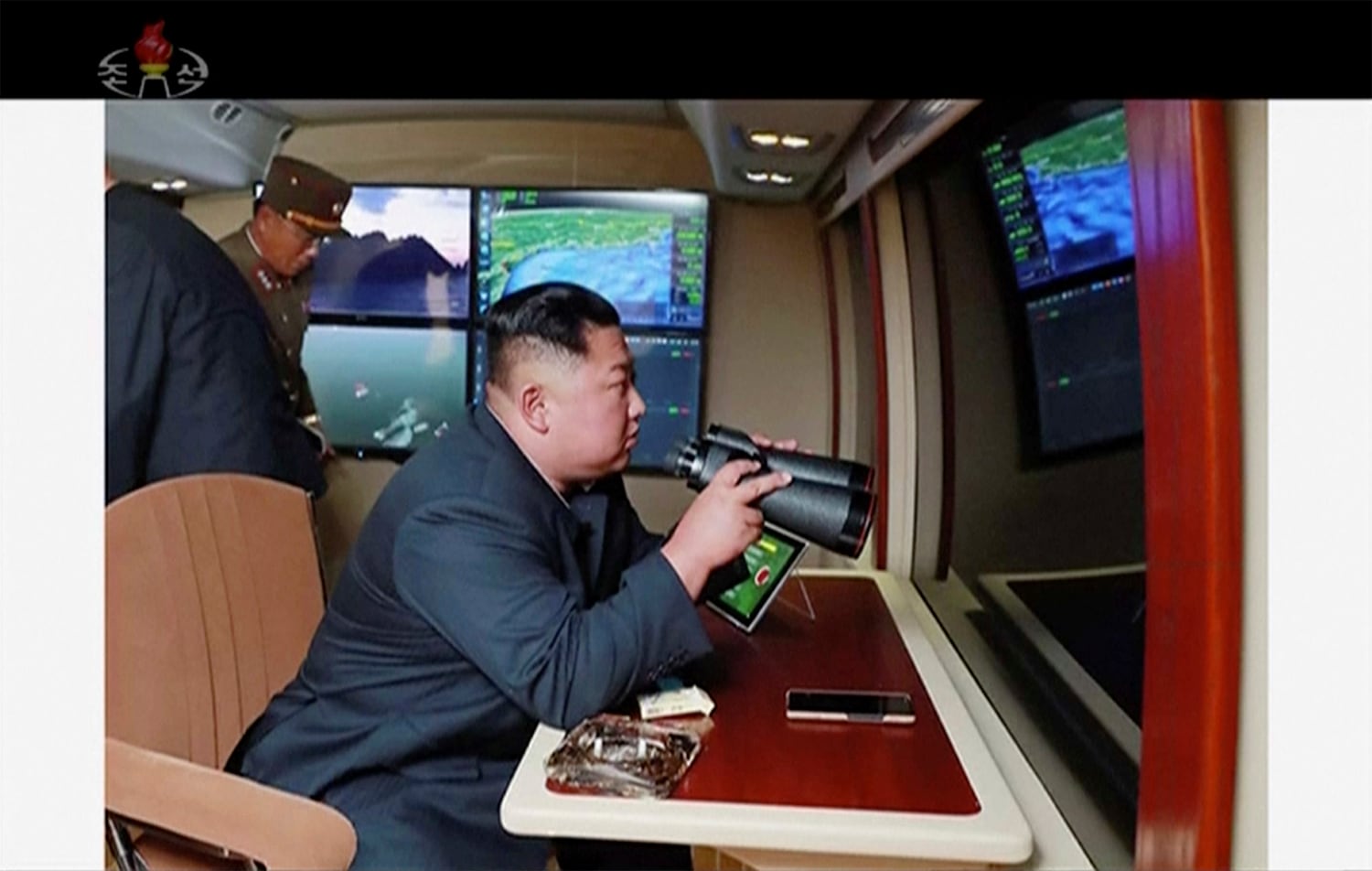 North Korean leader Kim Jong Un, equipped with binoculars, supervises a rocket launch test on Aug. 1, 2019.