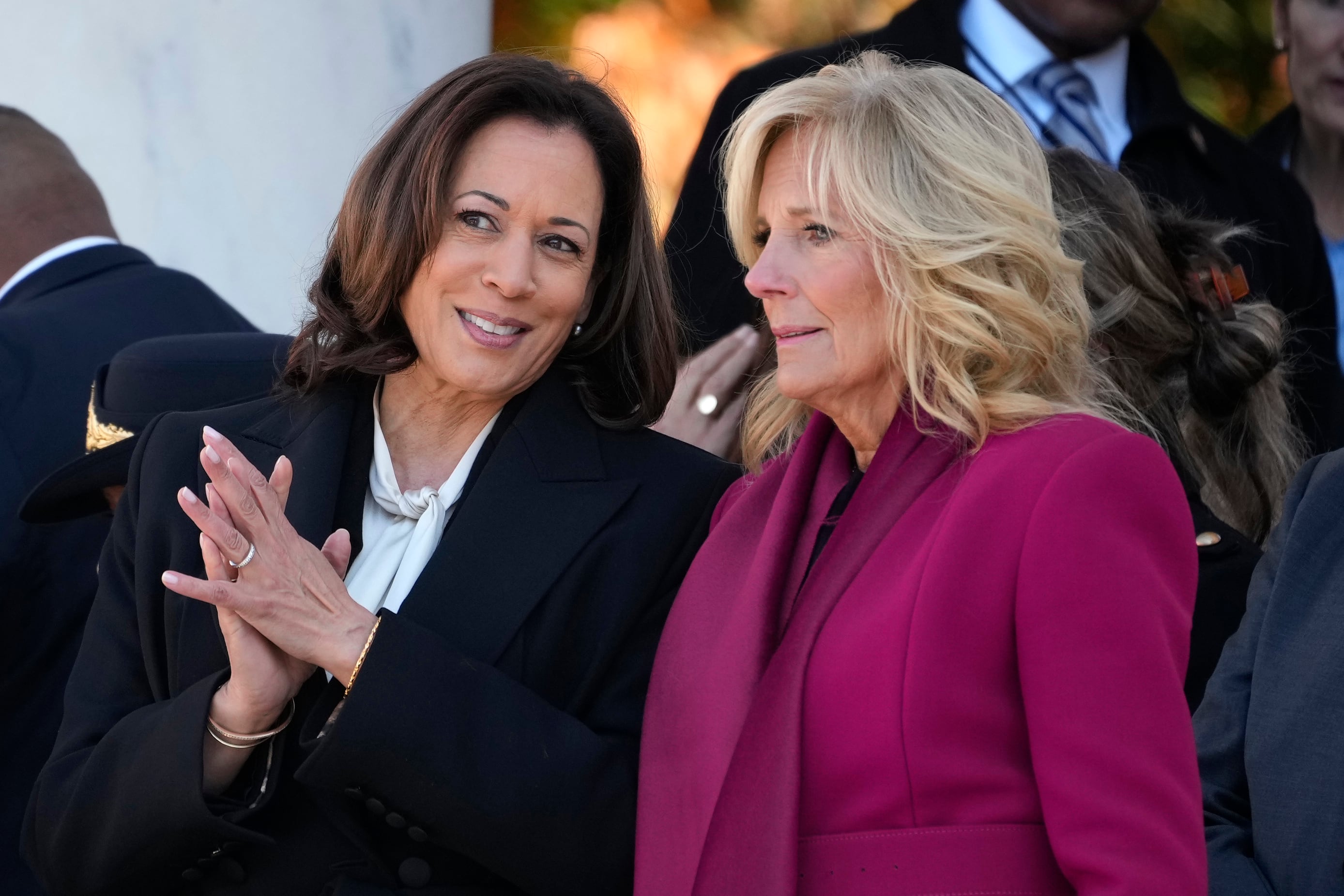 Vice President Kamala Harris talks with first lady Jill Biden before President Joe Biden speaks at the National Veterans Day Observance at the Memorial Amphitheater at Arlington National Cemetery in Arlington, Va., Saturday, Nov. 11, 2023.