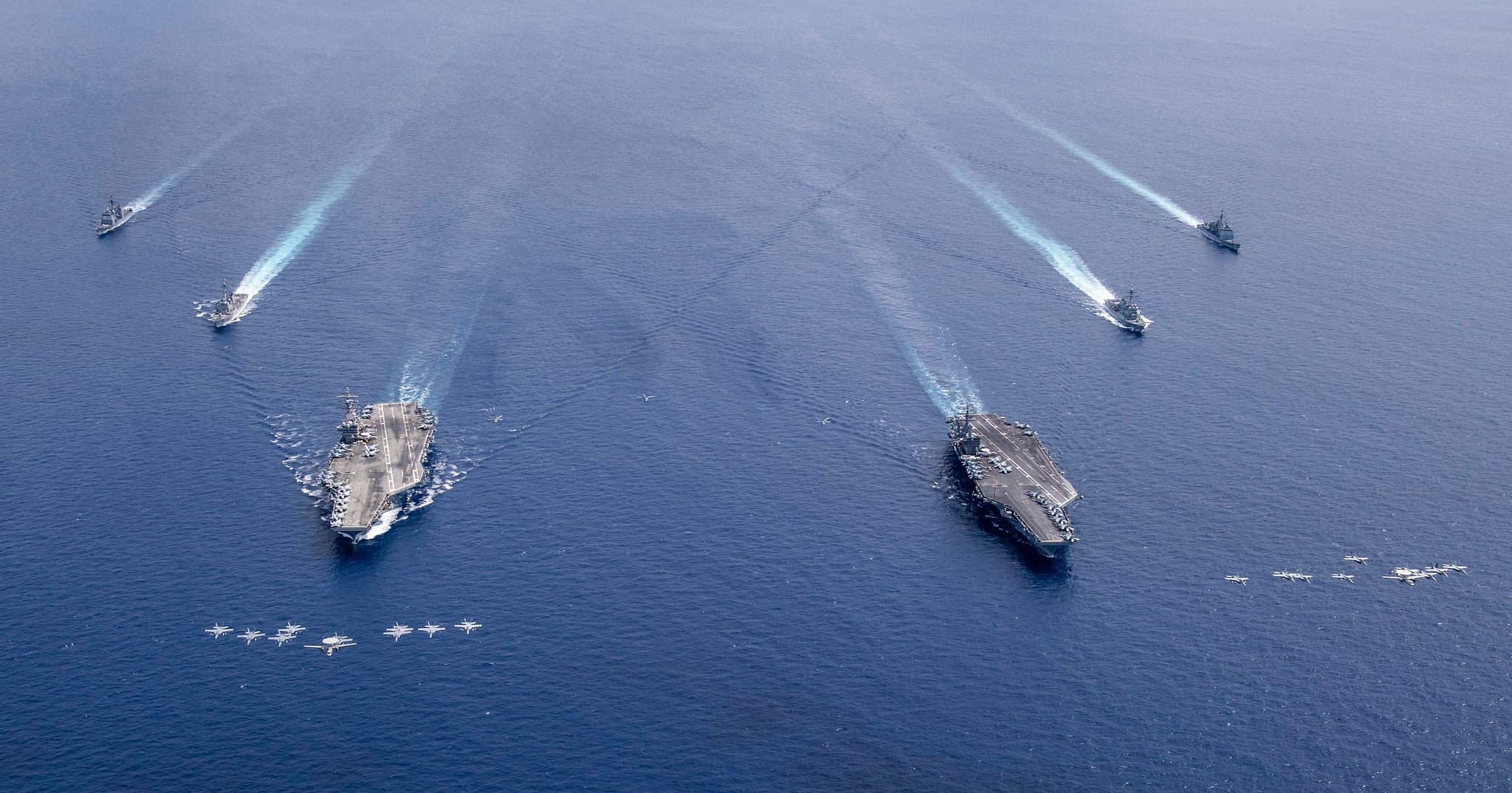 Aircraft from Carrier Air Wings (CVW) 5 and 17 fly in formation over the Nimitz Carrier Strike Force on July 6, 2020, in the South China Sea.