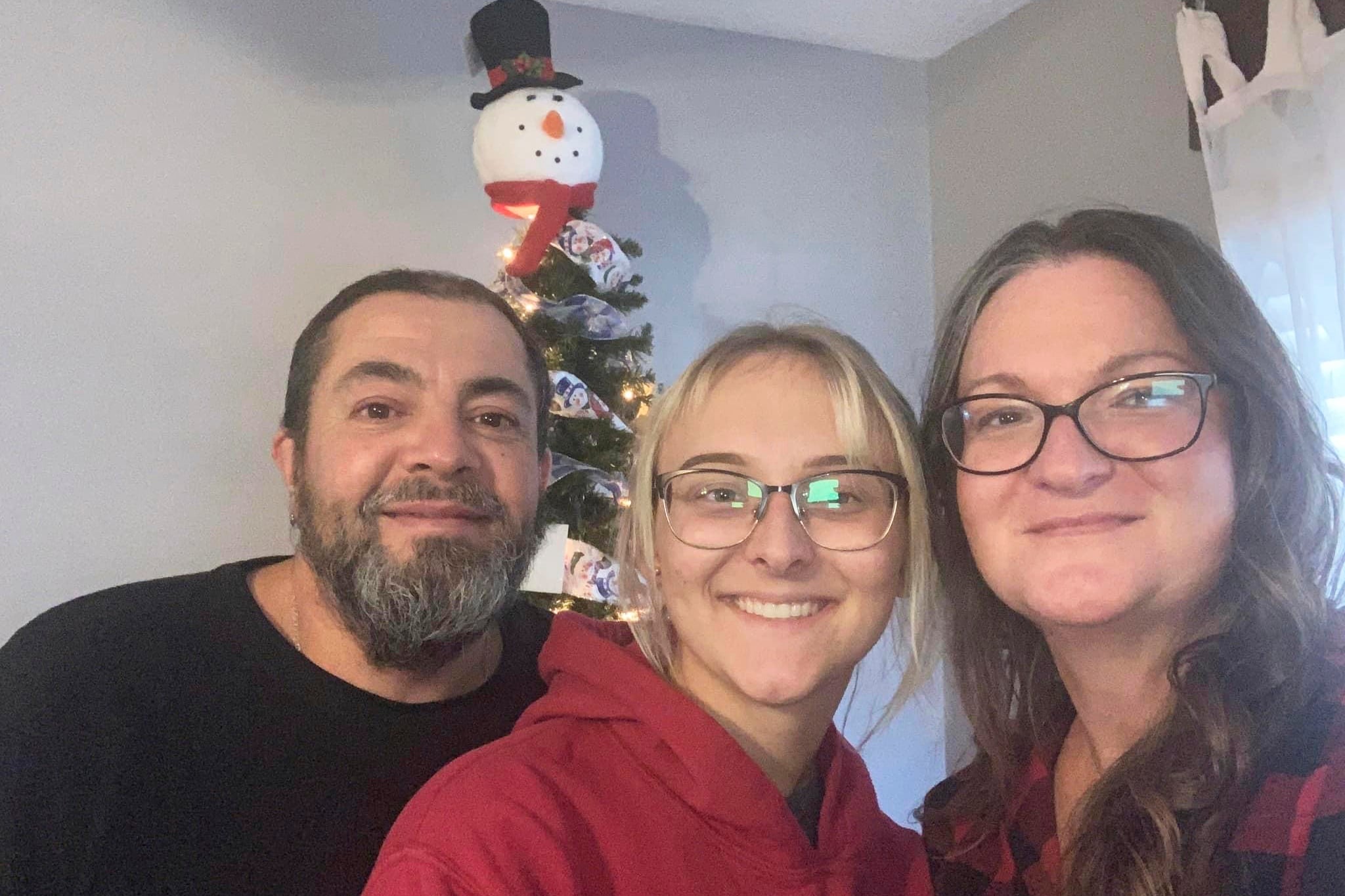 In this image provided by Metika Beck Burke, Pfc. Amiah Manlove, center, who is stationed with the Army in Oahu, Hawaii, poses her mom Metika Beck Burke, right, and stepfather Stoney Burke, when she was finally able to make it home to Indianapolis on Sunday, Dec. 25, 2022.