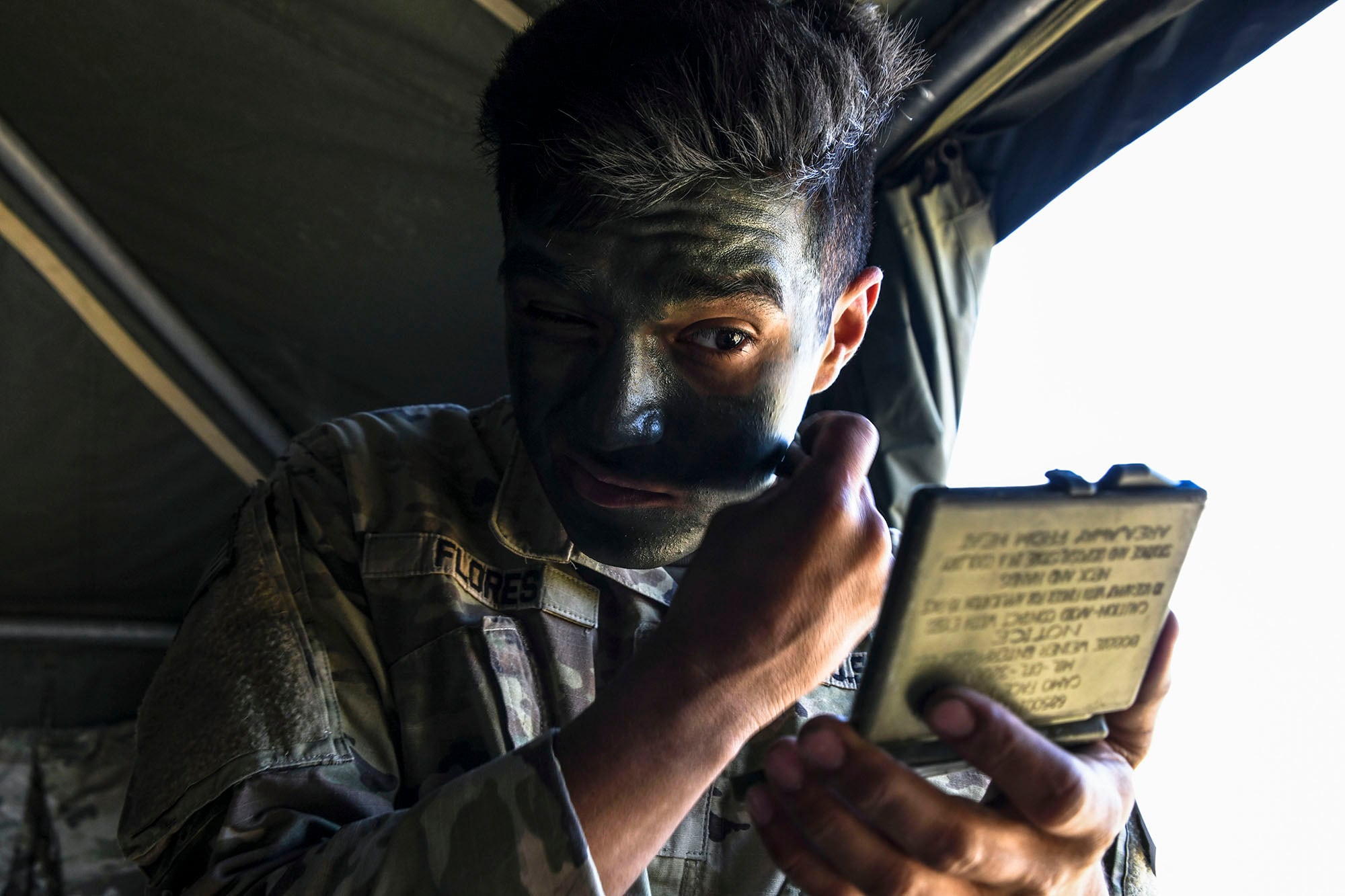 Army Spc. Christian Flores applies face paint prior to mission during the U.S. Army Europe European Best Warrior Competition at U.S. Army Garrison Hohenfels Training Area, Germany, July 29, 2020.