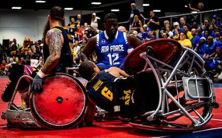 Air Force Senior Airman DeMarcus Garrett, Team Air Force athlete, powers through Team Navy defenders during the Department of Defense Warrior Games wheelchair rugby finals