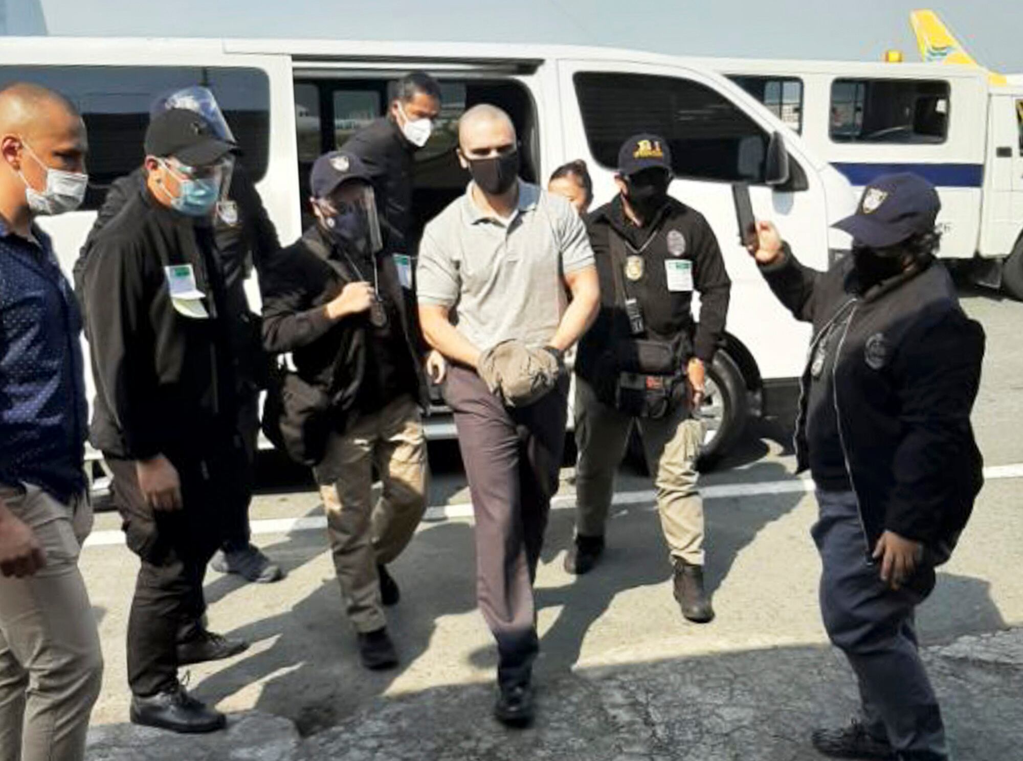 U.S. Marine Lance Cpl. Joseph Scott Pemberton, center, is escorted as he arrives at the airport before boarding a U.S. military plane in Manila, Philippines, Sunday, Sept. 13, 2020.