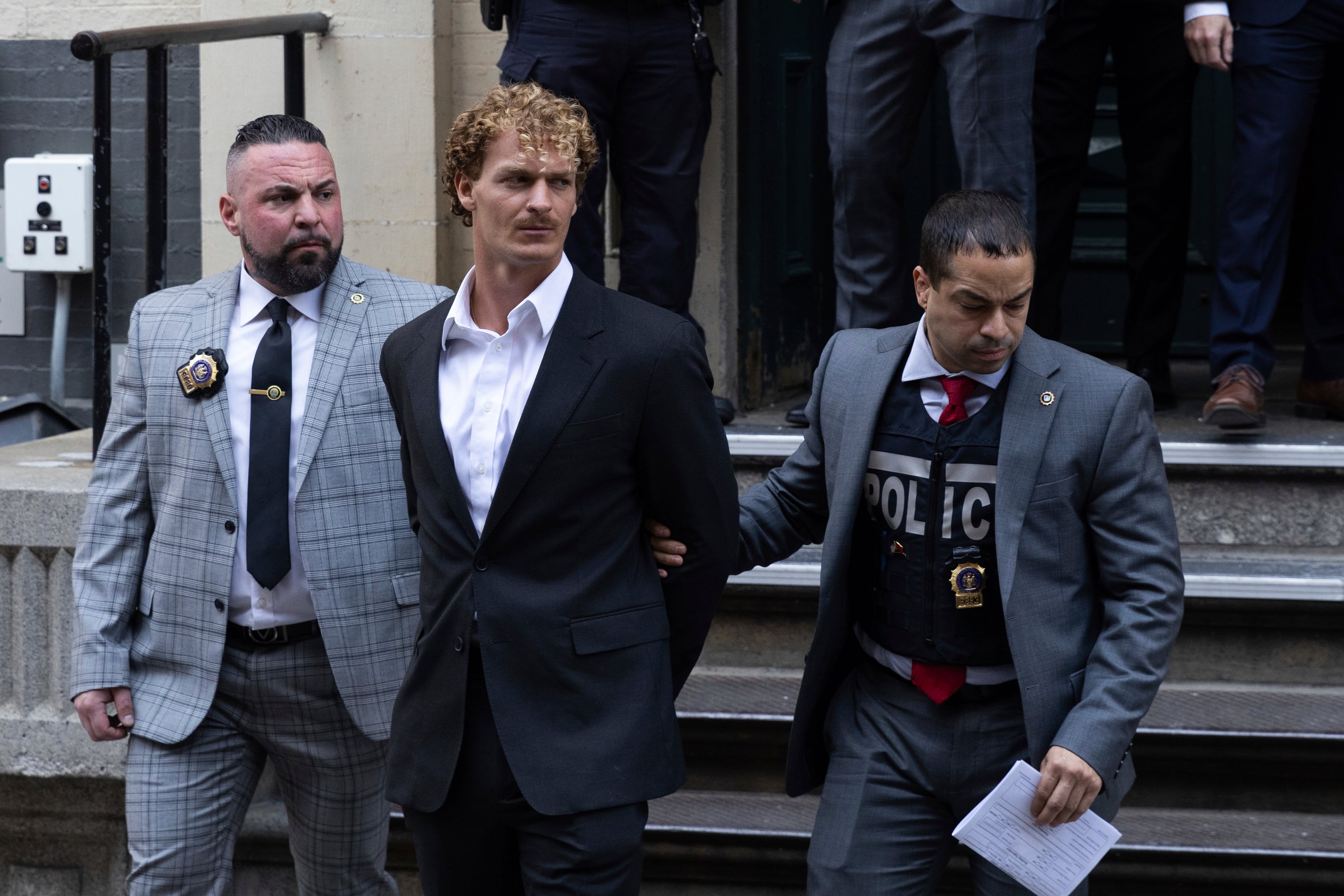 Daniel Penny, center, is walked by New York Police Department detectives detectives out of the 5th Precinct on Friday, May. 12, 2023 in New York.