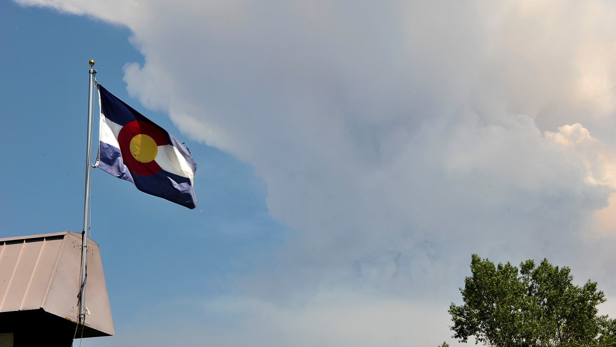 A Colorado flag flies over the West Fork Complex Fire as seen from Pagosa Springs Colo., June 27, 2013.