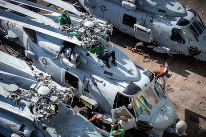 Sailors perform maintenance on an MH-60R Sea Hawk on Jan. 27, 2021, on the flight deck aboard the Nimitz-class aircraft carrier USS Dwight D. Eisenhower (CVN 69) in the Atlantic Ocean.