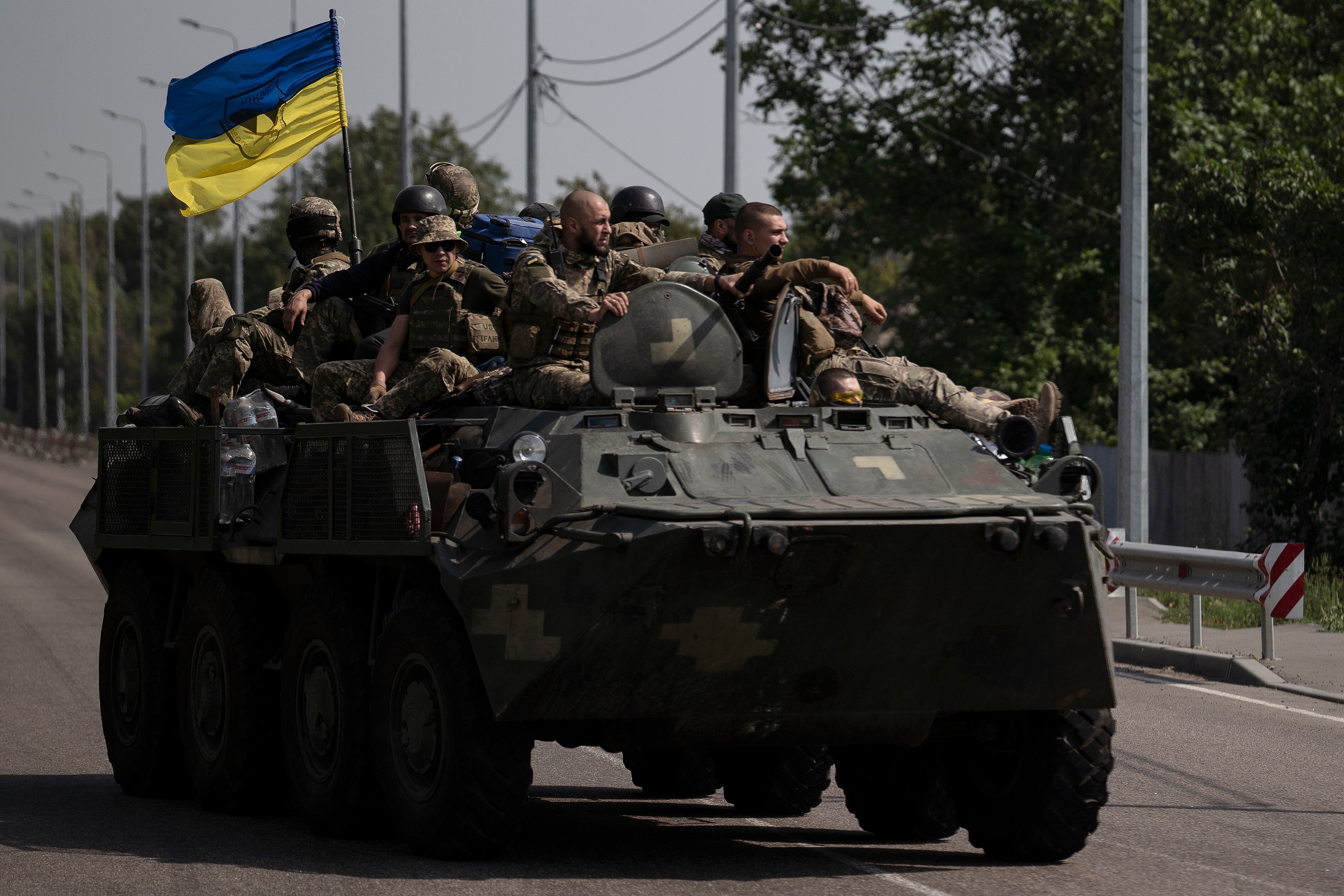 Ukrainian servicemen ride atop of an armored vehicle on a road in Donetsk region, eastern Ukraine, Sunday, Aug. 28, 2022.