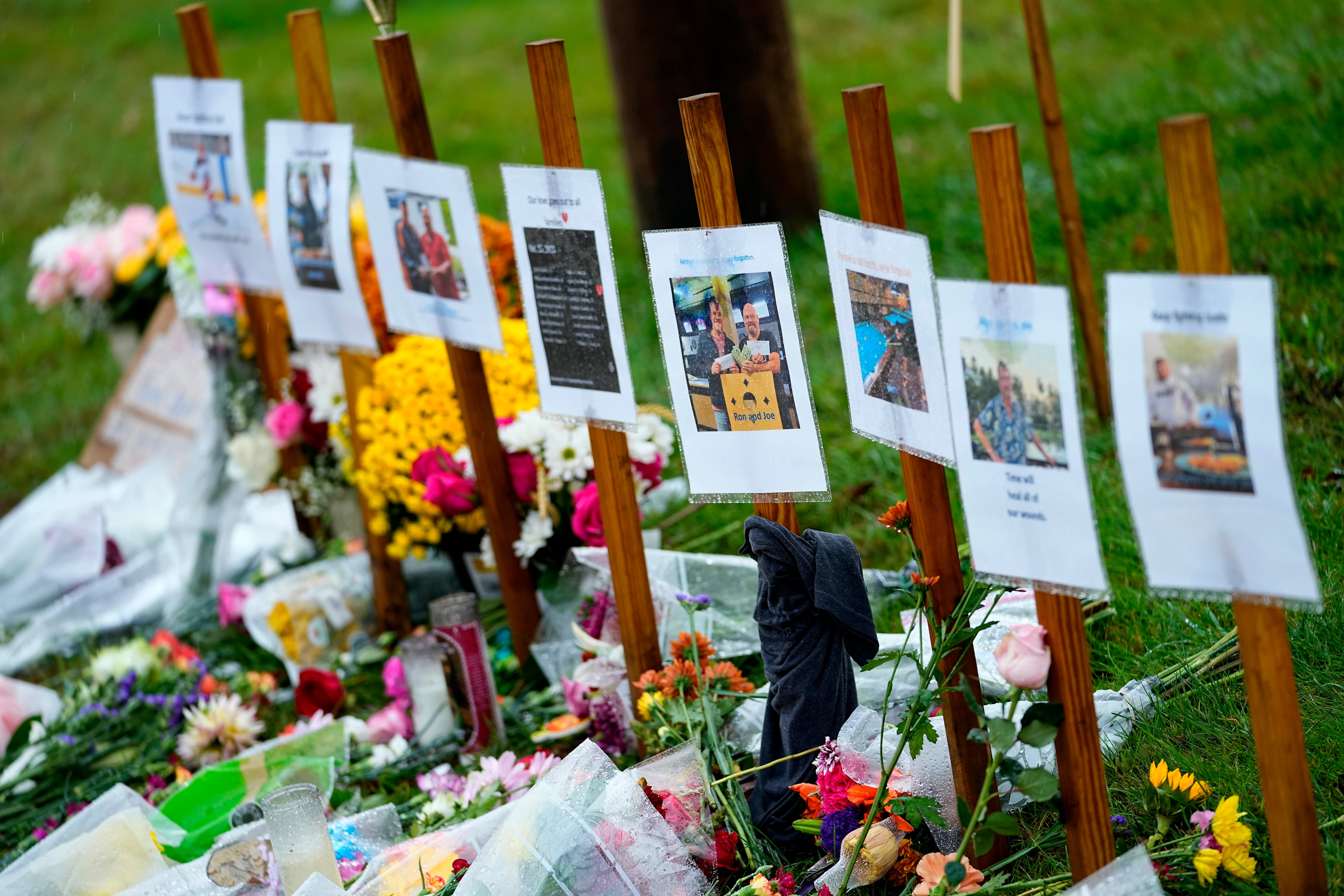 Rain soaked memorials for those who died sit along the roadside by Schemengees Bar & Grille, Monday, Oct. 30, 2023, in Lewiston, Maine.